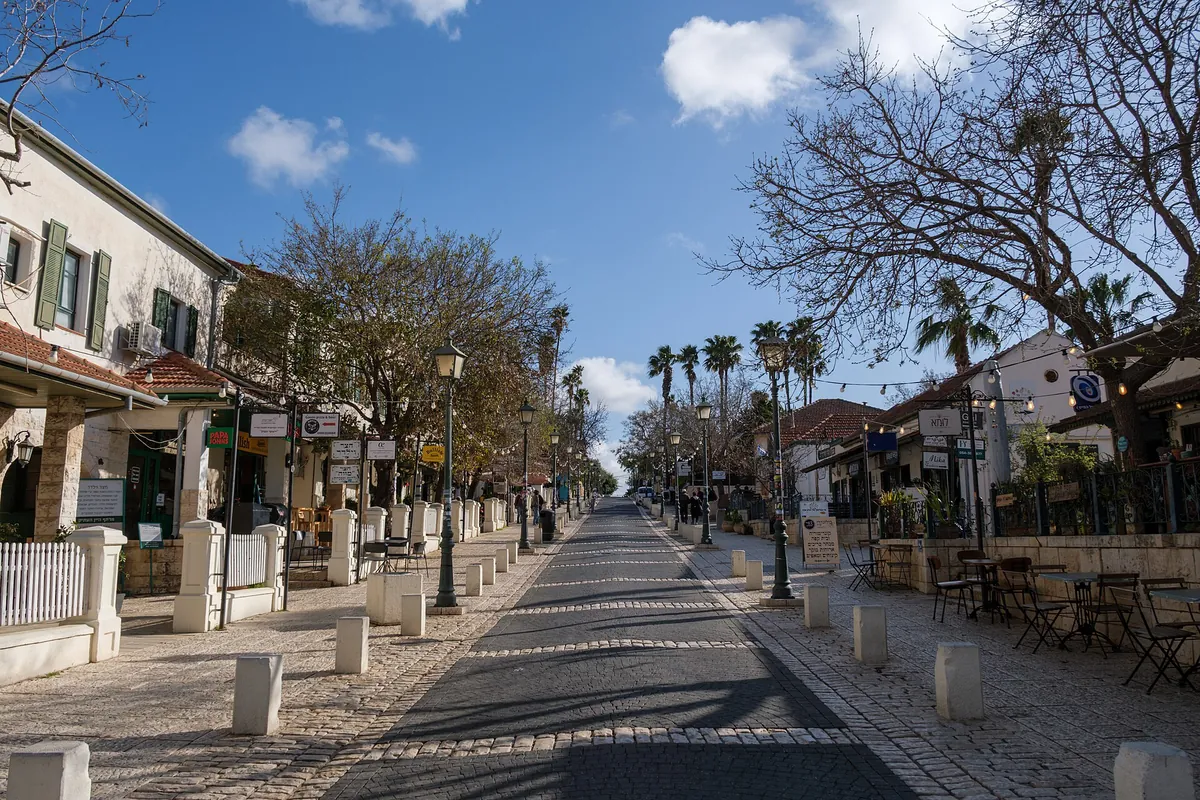 HaMeyasdim Street, the Midrachov of Zichron Yaakov: a paved pedestrian street with old stone houses, street lamps and palm trees